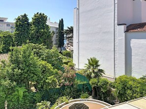 Ein Wohngebiet mit einem weißen Gebäude, üppiger Bepflanzung und blauem Himmel.