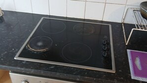 A kitchen with a stove, oven, and tiled backsplash. - Room-room in a Family House (Grays)