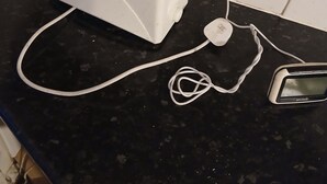 A white toaster on a black countertop with a power outlet and a white cord. - Room-room in a Family House (Grays)