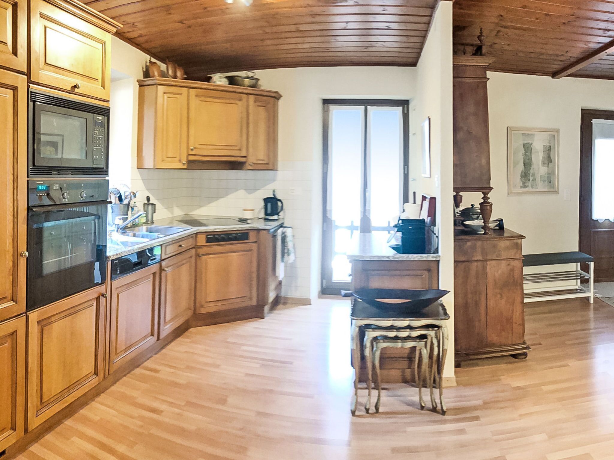 Una cocina con gabinetes de madera, estufa y pileta.