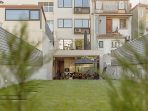 Ein modernes Wohngebäude mit flachem Dach, zahlreichen Fenstern und einem sichtbaren Balkon.