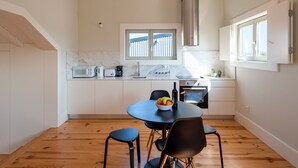 Eine moderne Küche mit Essbereich, ausgestattet mit Backofen, Mikrowelle und einem großen Fenster.