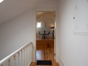 A staircase leading to a dining area with a table and chairs, a window, and a radiator. - Apartment  by Interhome (Porto)