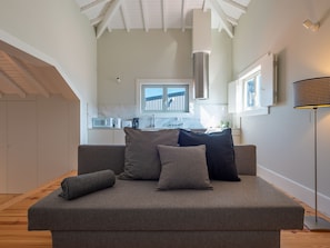 A modern living room with a grey sofa, a coffee table, and a floor lamp. - Apartment  by Interhome (Porto)