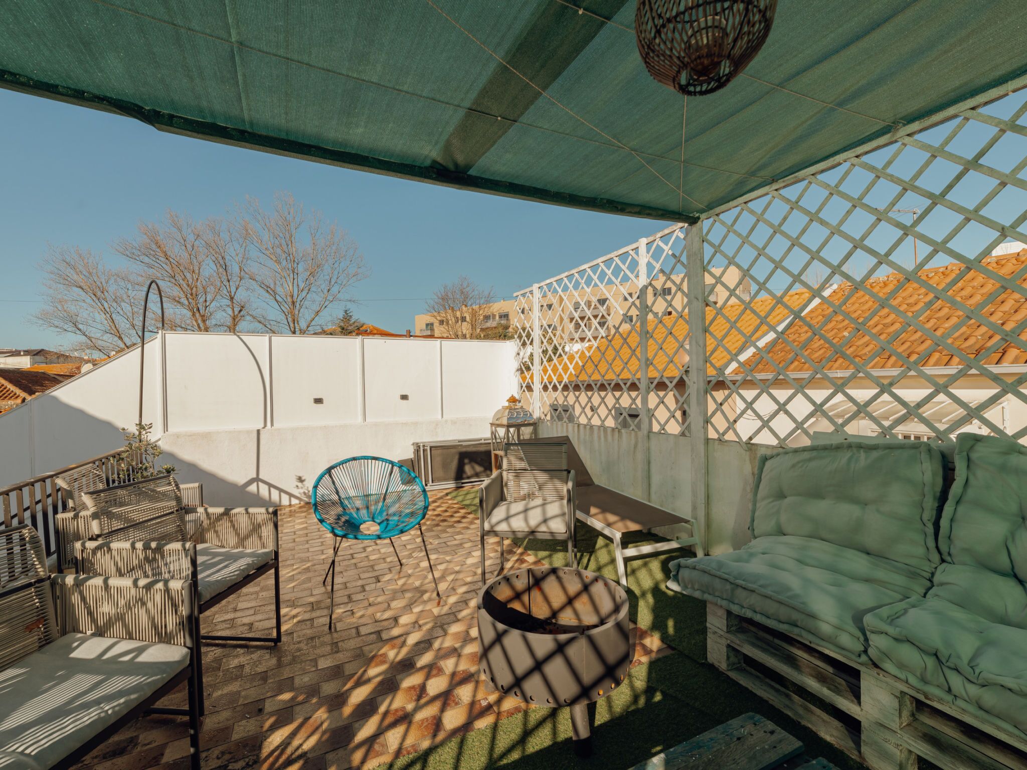 Una terrazza esterna con divano, sedie e tavolo.
