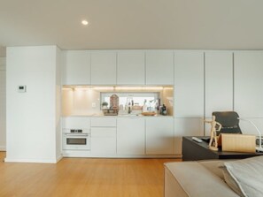 Een koelkast, een magnetron, een oven, kookgerei, borden en bestek