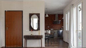Eine moderne Küche mit Backsteinwand, einem Essbereich mit Stühlen und einer Holztür.