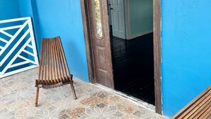 Una habitación con pared azul, puerta de madera y piso estampado.