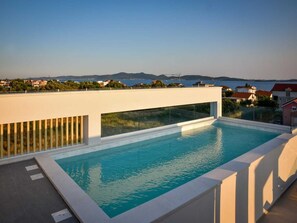 A rooftop infinity pool with a clear view of the sea and distant mountains. - Apartment  by Interhome (Zadar/Bibinje)