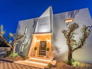 A modern villa named 'Villa Michelle' with a well-lit entrance, a small garden with cacti, and a paved pathway leading to the door. - Luxury Villa Michele with infinity pool by Interhome (Rovanjska)