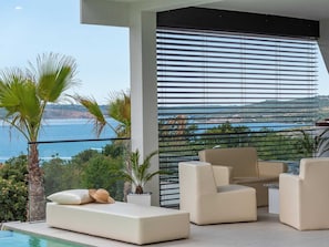 A modern outdoor seating area with a pool, overlooking a coastal landscape. - Luxury Villa Michele with infinity pool by Interhome (Rovanjska)