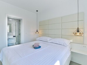 A modern bedroom with a large bed, a headboard, and two pendant lights. - Apartment  by Interhome (Zadar/Bibinje)