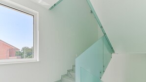 Eine Treppe mit Glastrennstäben und weißen Marmorstufen.