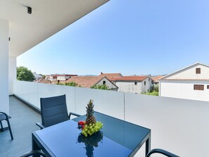 A balcony with a table, chairs, and a fruit arrangement. - Apartment  by Interhome (Zadar/Bibinje)