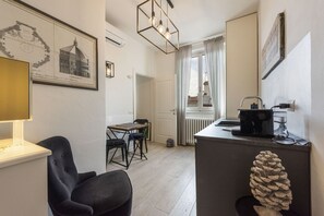 Ein modernes Zimmer mit Esstisch, Stühlen, einer Lampe, einem Heizkörper und einer Kiefernzapfen-Dekoration.