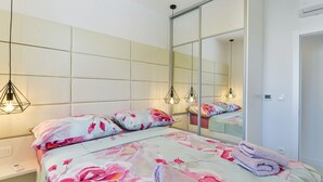 Un dormitorio con cama, un espejo grande y un armario.