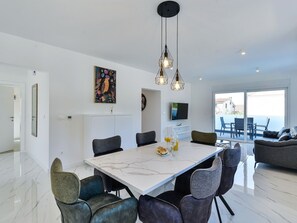 A modern dining area with a marble table, upholstered chairs, and pendant lighting. - Villa Div with heated pool Apartment No.1 by Interhome (Zadar/Bibinje)