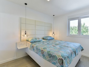 A bedroom with a bed, bedside table, and two pendant lights. - Villa Div with heated pool Apartment No.1 by Interhome (Zadar/Bibinje)