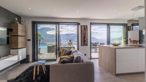 Ein modernes Wohnzimmer mit einer Couch, einem kleinen Tisch und einer Küchenzeile.