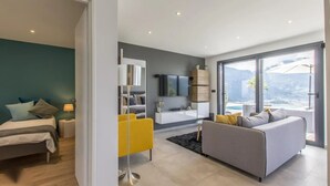 Ein modernes Wohnzimmer mit Bett, Sofa und Fernseher.
