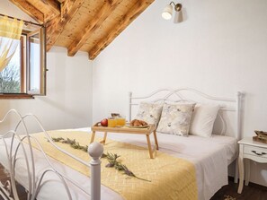 A bedroom with a bed, bedside table, and a window with curtains. - Holiday Home Marilu with pool by Interhome (Budak)