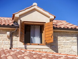 Une pièce dotée d’une petite fenêtre de toit, de murs en pierre et d’une toiture en tuiles de terre cuite.