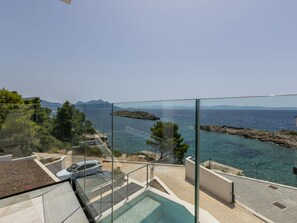 A modern outdoor pool area with clear views of the sea and distant mountains. - Beachfront villa Luce with seaview and pool by Interhome (Trstenik/Dingač)