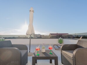 A rooftop terrace with wicker furniture, a table with drinks, and a white umbrella. - Stunning Villa Marea with a private pool by Interhome (Vrsi)