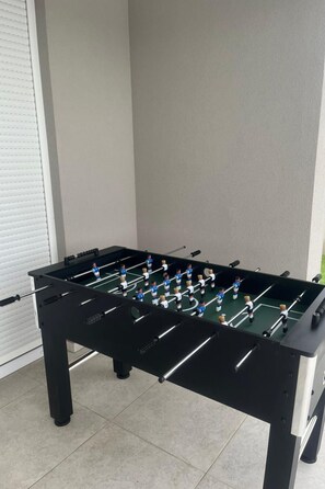 A foosball table with a black frame and a green playing surface, located indoors with a tiled floor. - Stunning Villa Marea with a private pool by Interhome (Vrsi)