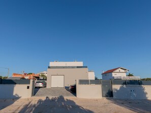 A modern building with a garage entrance, a car parked inside, and a clear sky. - Stunning Villa Marea with a private pool by Interhome (Vrsi)