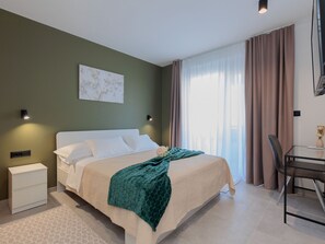 Ein Hotelzimmer mit Bett, Nachttischen, Schreibtisch und Stuhl.