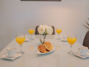 A breakfast setting with croissants, orange juice, and a vase of flowers on a table. - Stunning Villa Marea with a private pool by Interhome (Vrsi)