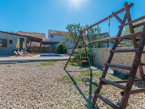A residential property with a swimming pool, outdoor seating, and a wooden swing set. - Holiday Home Ema with pool by Interhome (Biograd na Moru)