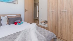 Ein Schlafzimmer mit einem Bett, einem Kleiderschrank und einem Gemälde an der Wand.