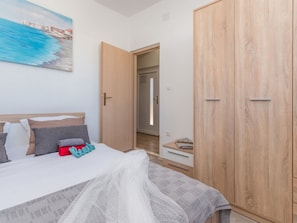 A bedroom with a bed, a wardrobe, and a painting on the wall. - Holiday Home Ema with pool by Interhome (Biograd na Moru)