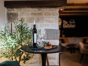 A table with a bottle of wine, glasses, and a plate of olives and nuts. - Villa Barbara with heated pool by Interhome (Drage)