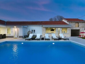 A residential property with a swimming pool, lounge chairs, and a stone facade. - Villa Mare with heated pool and gym by Interhome (Crno)