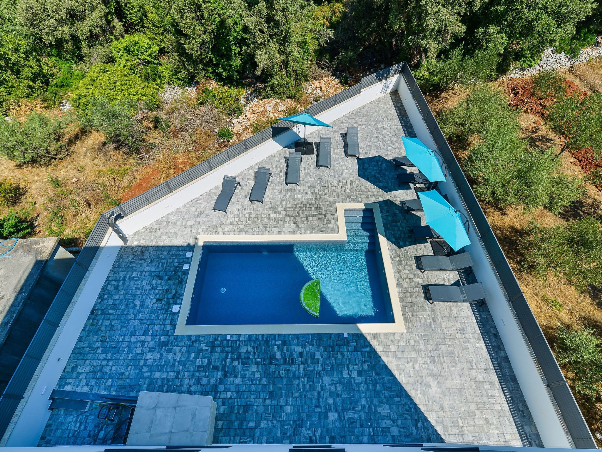 Luftaufnahme eines Dachpools mit Blick auf die umliegende Landschaft.