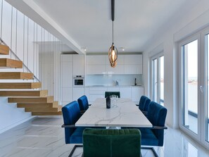A modern kitchen with a marble countertop, a built-in oven, and a hanging light fixture. - Apartment  by Interhome (Zadar/Bibinje)