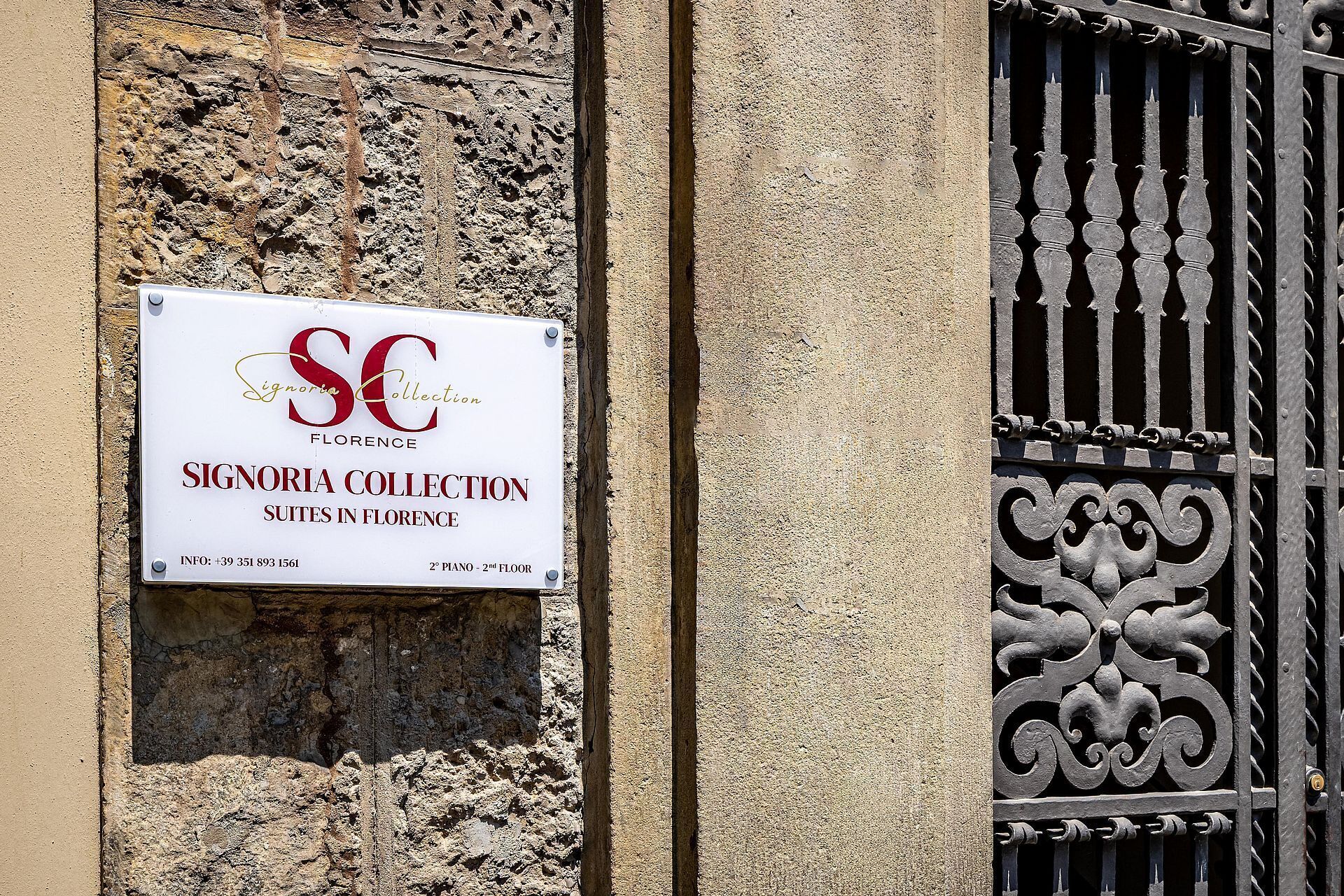 Letrero de Signoria Collection Suites en Florencia, con un número de contacto y la ubicación del piso.