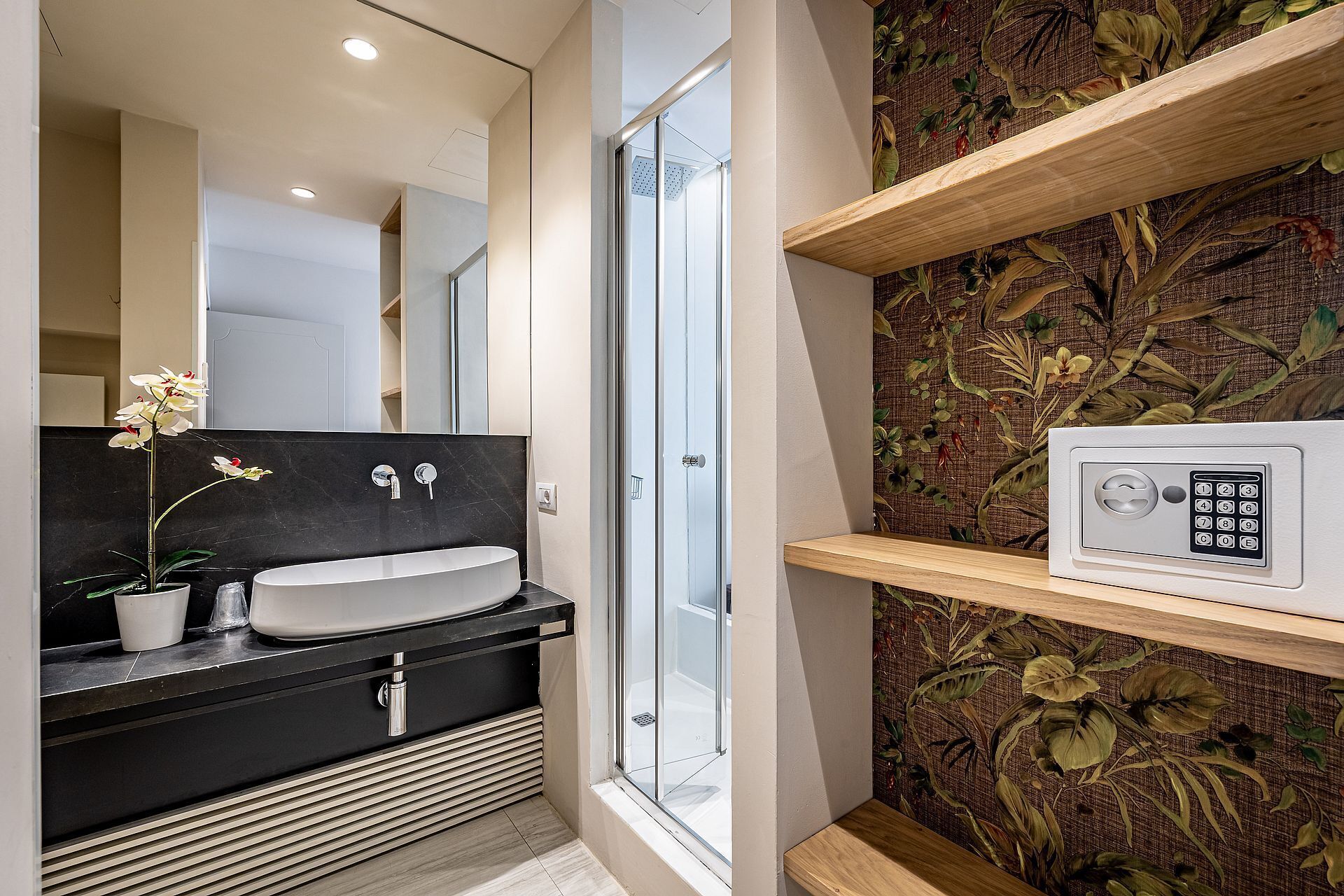 Une salle de bain moderne équipée d’un lavabo, d’un miroir, d’une douche et d’un clavier numérique pour la sécurité.