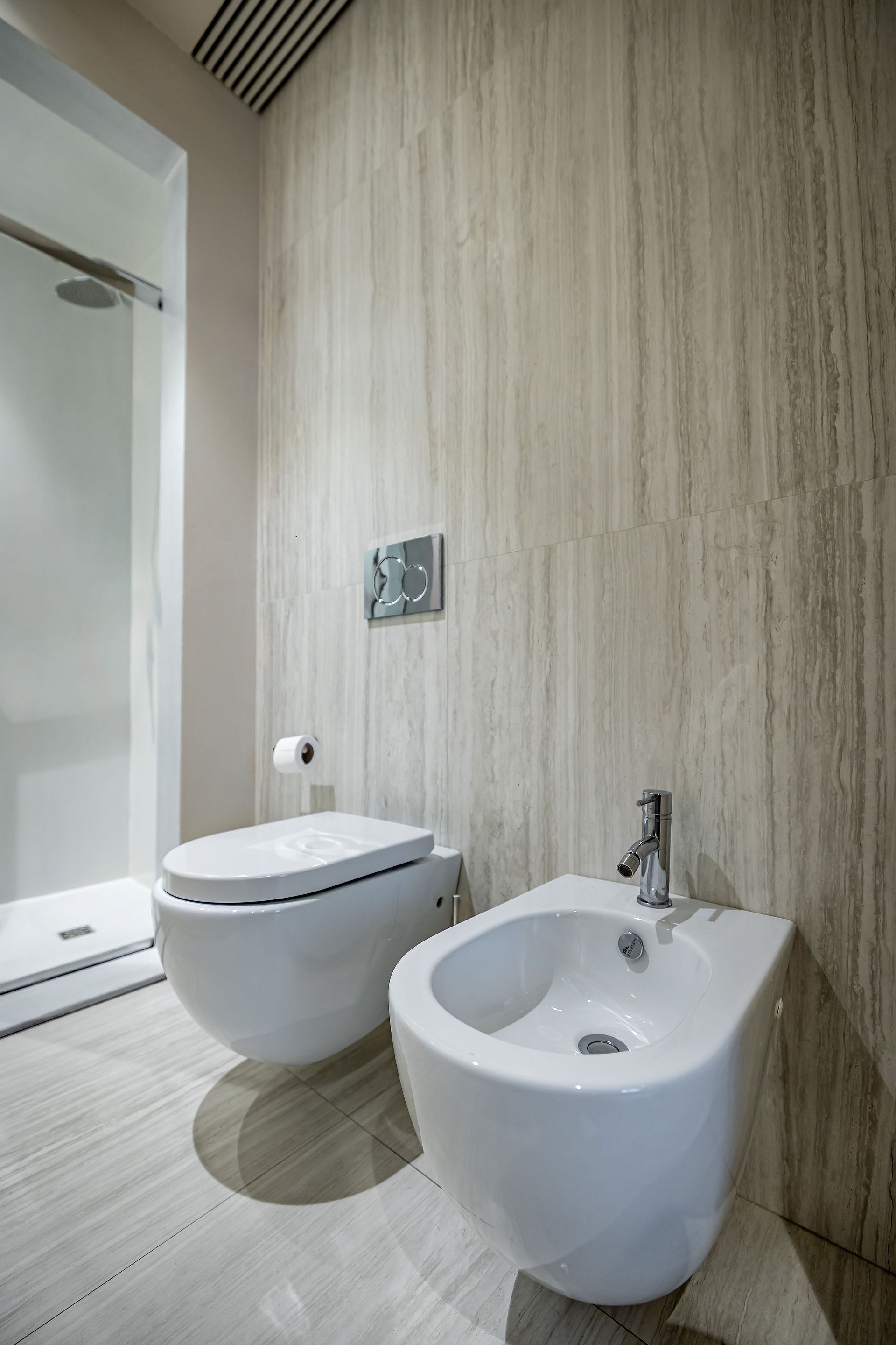 Ein modernes Badezimmer mit integriertem Bidet, Toilette und Duschbereich.