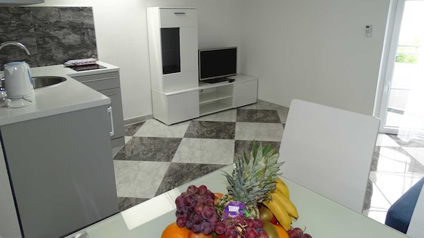 Una cocina moderna con comedor, televisor y frutero.