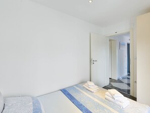 Ein Hotelzimmer mit einem Bett, einer Tür und Blick auf den Flur.