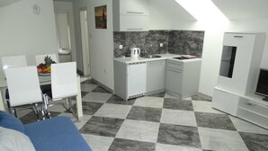 Un apartamento moderno y compacto con kitchenette, comedor y sala de estar.