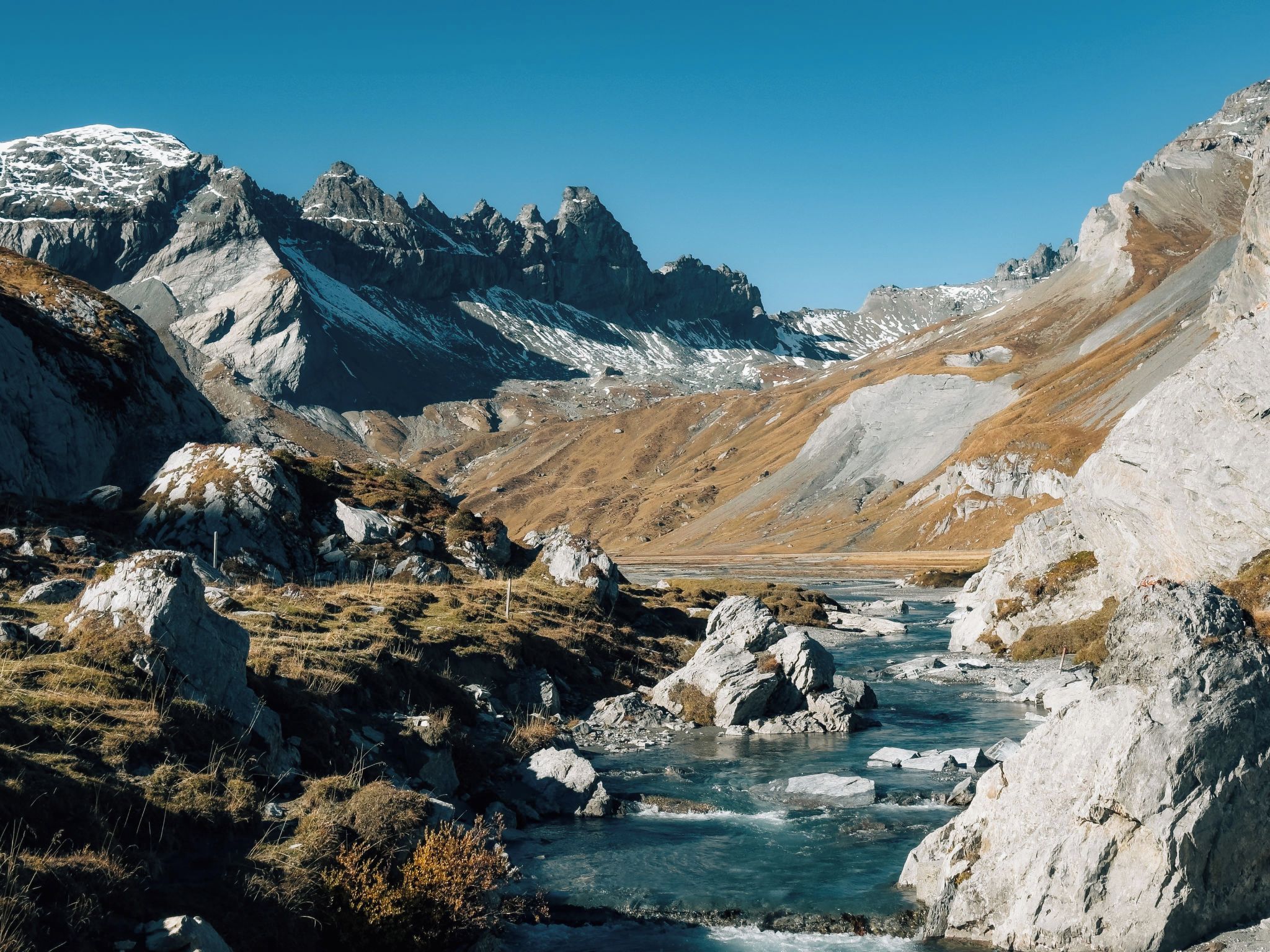 A mountainous landscape with a river flowing through a rocky valley.