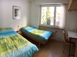 A bedroom with two single beds, a desk, and a chair. - Haus Beta / Meier, (Flims Waldhaus), 48 by Interhome (Flims)