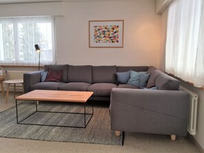 A living room with a grey sofa, a wooden coffee table, and a patterned rug. - Haus Beta / Meier, (Flims Waldhaus), 48 by Interhome (Flims)