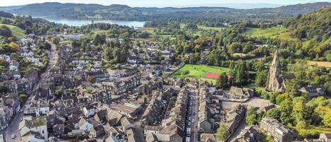 Vista aérea de uma cidade com edifícios históricos, uma igreja e um campo de esportes.