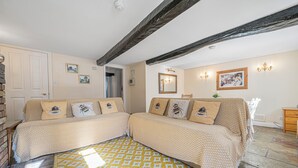 A room with a bed, a wooden bench, a mirror, and a picture on the wall. - 7 Grade II Listed Cosy Cottage Free Parking (Ambleside)